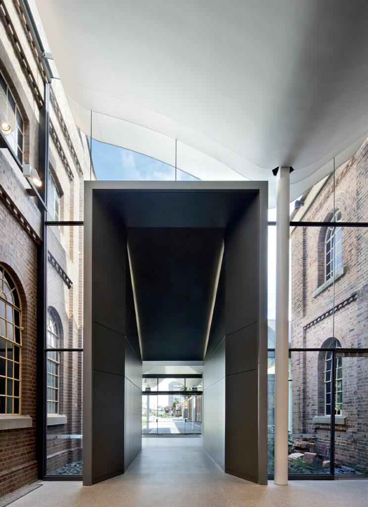 Newcastle Museum, designed by fjmt: A museum below clouds and historic brickwork.